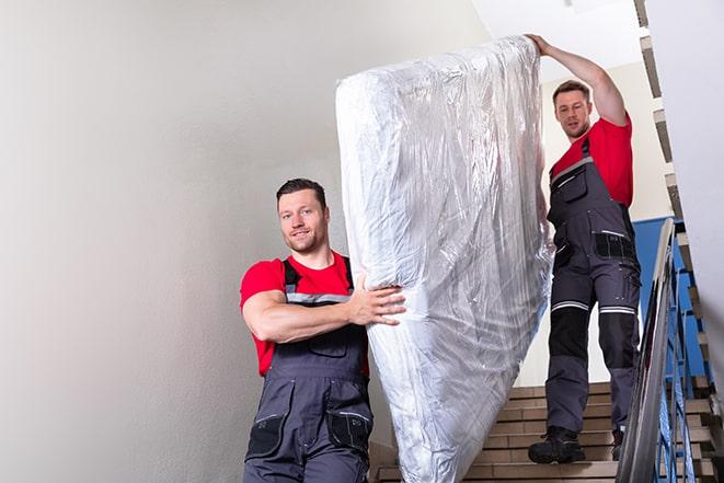 decluttering process involving the removal of a box spring in Affton